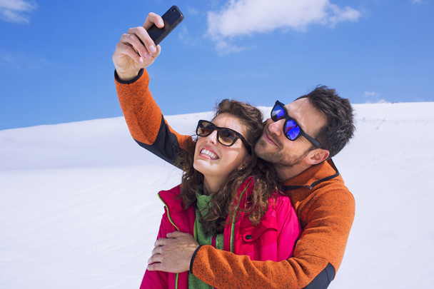 Couple having a selfie on the snow in montain - Photo, Image