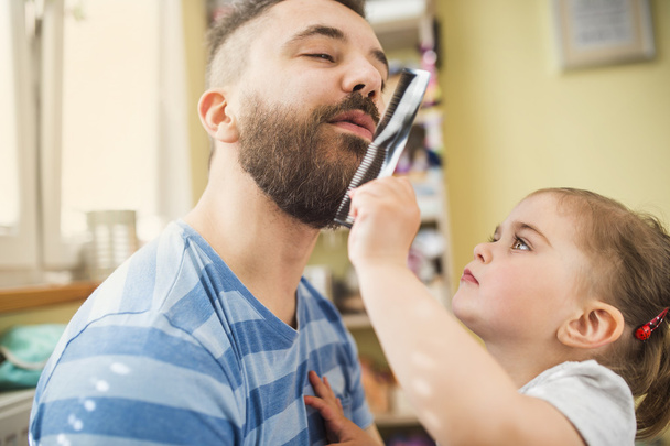 Girl styling beard of her father - Foto, afbeelding