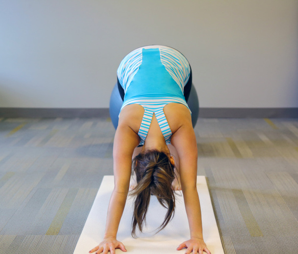 Female yoga excersise on a white mat - Foto, Bild