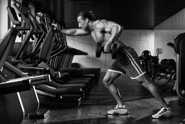 Bodybuilder Exercising Back With Dumbbell - Fotó, kép