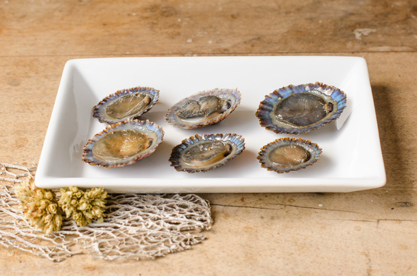 Raw limpets, rustic background. - Photo, Image