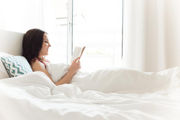 Γυναίκα ανάγνωση στο κρεβάτι - Φωτογραφία, εικόνα