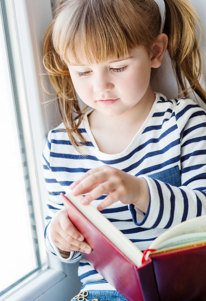 heureuse petite fille tenant un livre
  - Photo, image