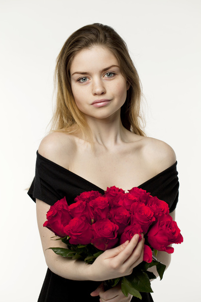 Portrait of a young beautiful girl with a bouquet of red roses - Foto, Bild