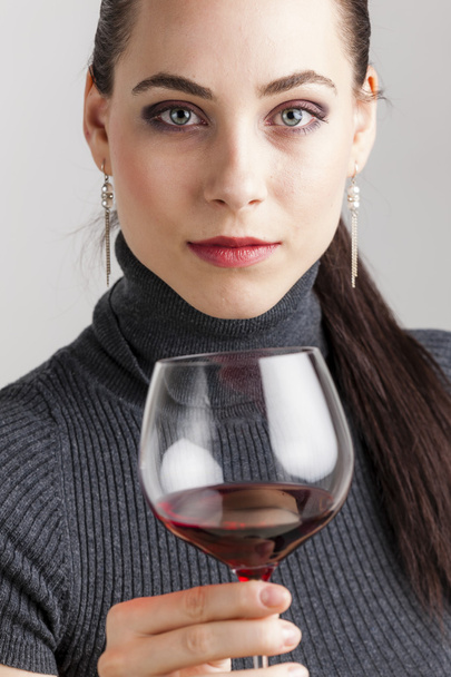 Jeune femme avec un verre de vin rouge - Photo, image
