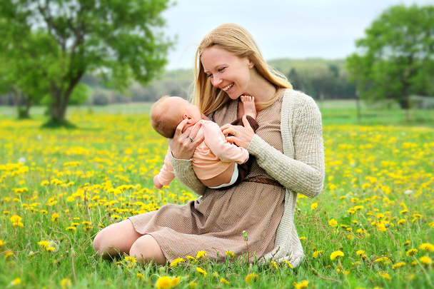 生まれたばかりの赤ちゃんは外で遊んで幸せな若い母 - 写真・画像