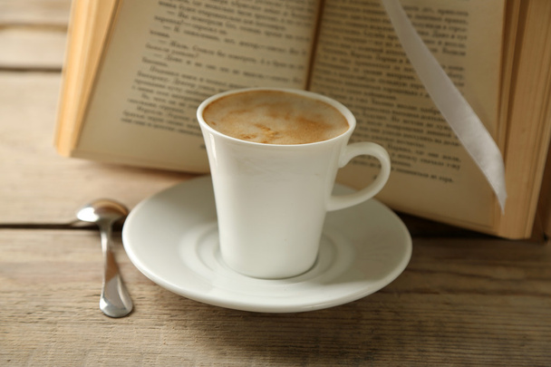 Bodegón con taza de café y libro, sobre mesa de madera
 - Foto, Imagen