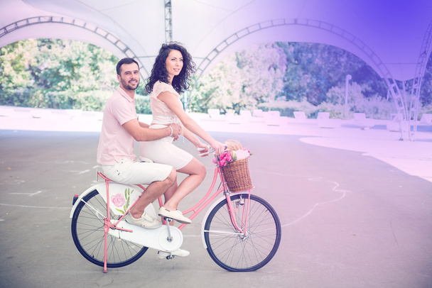 Couple with pink vintage bicycle in the summer park - Fotó, kép