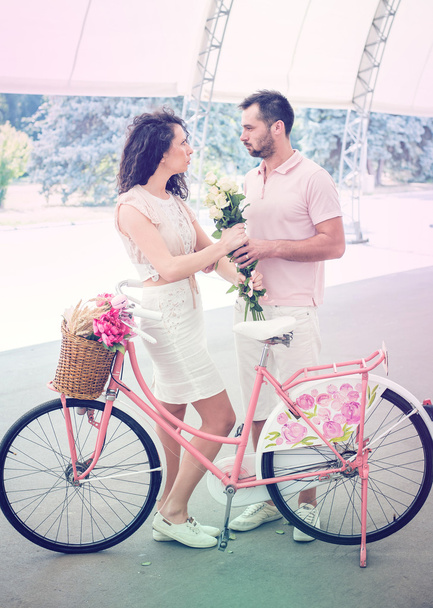 Couple with pink vintage bicycle in the summer park - Foto, imagen