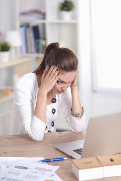 Stressed businesswoman sitting at desk - Foto, afbeelding