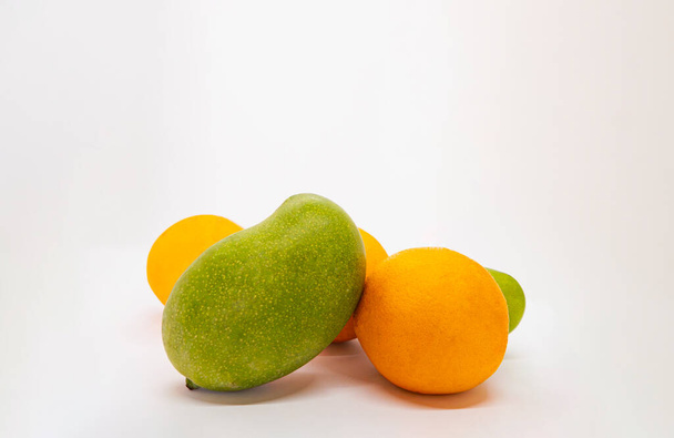 Змішані фрукти Ізольовані білий фон Тропічні манго та апельсини Мандаринові вирізані скибочки в кошику - Фото, зображення