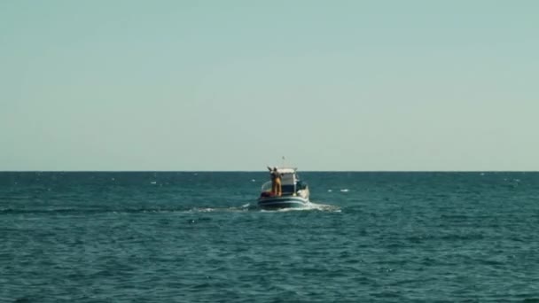 Рибалка-мореплавець на невеликому моторному човні указує на хоризонт
 - Кадри, відео