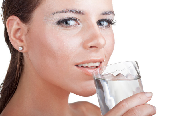 Wet beautiful woman drinks water from a glass - Photo, Image
