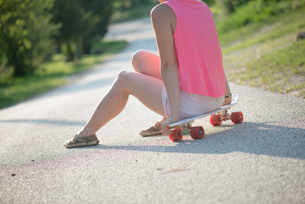 Блондинка-скейтбордистка отдыхает на открытом воздухе
 - Фото, изображение