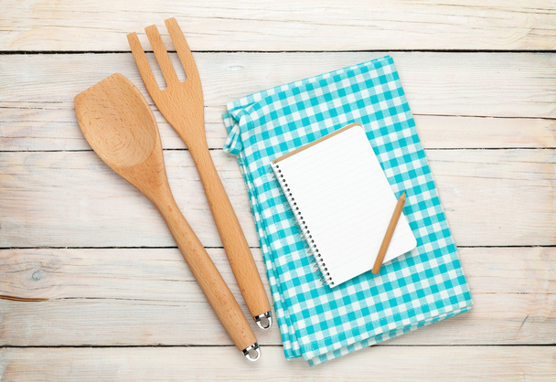 Keukengerei en notepad over houten tafel - Foto, afbeelding