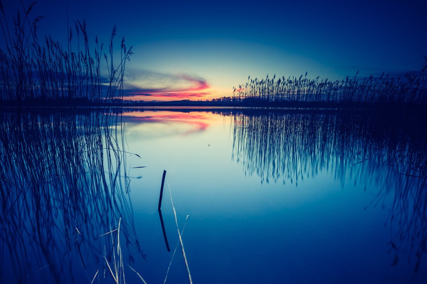 Zachód słońca nad spokojnym jeziorem - Zdjęcie, obraz