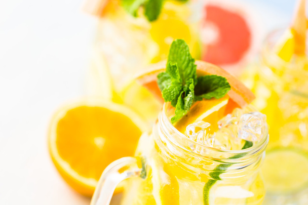 Water with fresh citrus fruits and ice - Fotó, kép