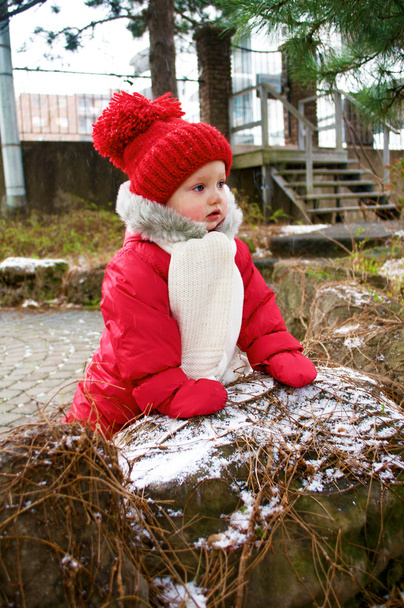 schattige babymeisje in de rode snowsuit - Foto, afbeelding
