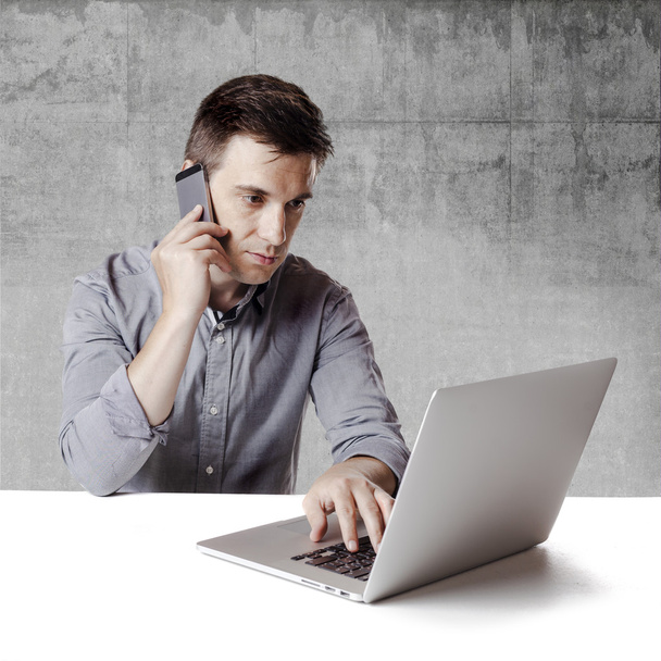 Close up image of multitasking business man using a laptop and mobile phone - Zdjęcie, obraz