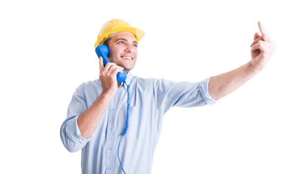 Engineer showing middle finger while talking on the phone - Photo, Image