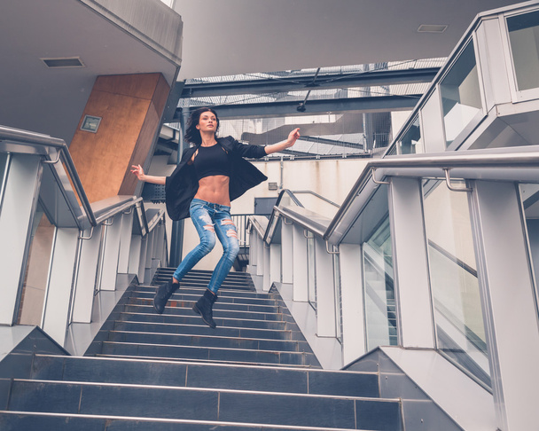 Beautiful girl jumping from a staircase - Foto, afbeelding
