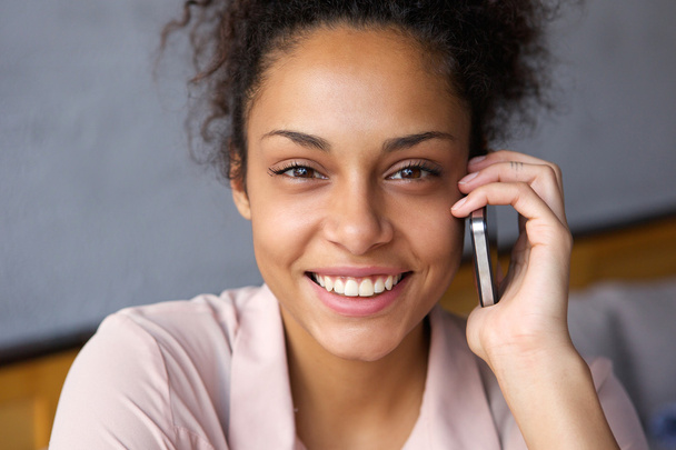glimlachende jonge vrouw praten op mobiele telefoon - Foto, afbeelding