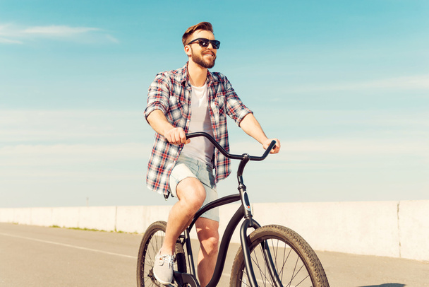 young man in eyewear riding bicycle - Photo, image