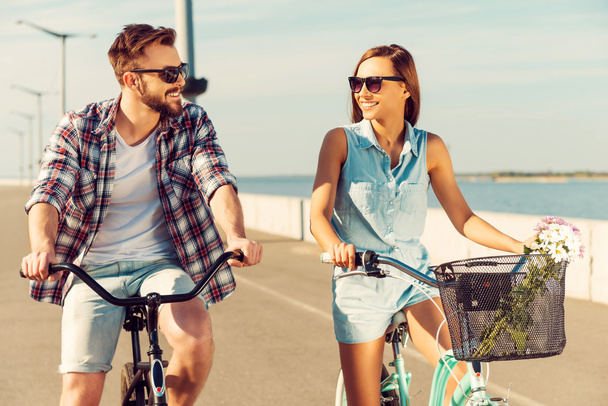 Cheerful couple riding on bicycles - Zdjęcie, obraz