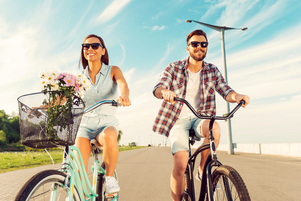 couple smiling and riding on bicycles - Foto, afbeelding