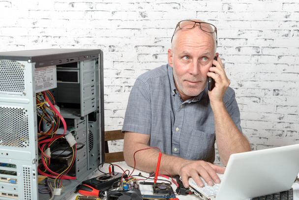 технік, який ремонтує комп'ютер і телефон для клієнта
 - Фото, зображення