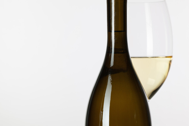 Glass of white wine and brown bottle  - Foto, afbeelding