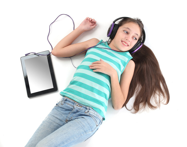 Belle fille pré-adolescente couchée sur le sol avec une tablette
 - Photo, image