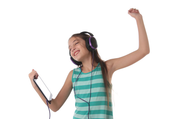 Beautiful pre-teen girl dancing with a tablet and headphones - Photo, Image