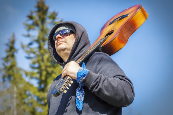 άνθρωπος με κιθάρα στον ώμο - Φωτογραφία, εικόνα