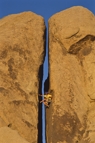 Bergsteiger klammert sich an eine Klippe. - Foto, Bild