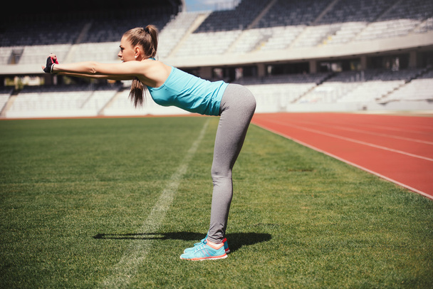 Female runner stretching, preparing for training. Fitness sportswoman warming up for running. - Foto, immagini