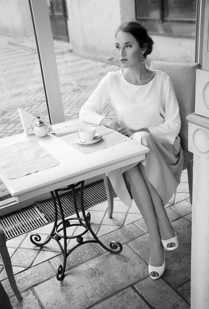 Kaunis tyylikäs blondi istuu kahvilassa juomassa teetä
 - Valokuva, kuva