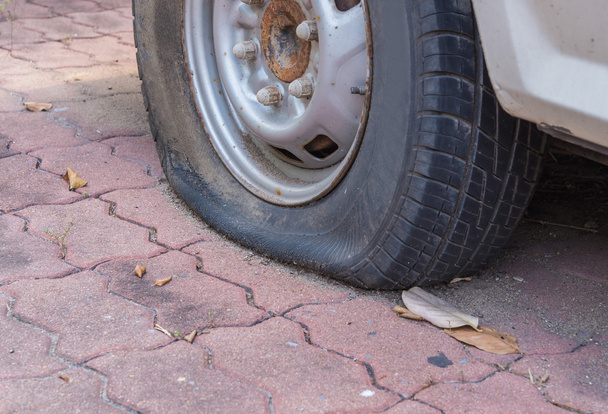 Neumático dañado desinflado en la rueda del coche
 - Foto, imagen