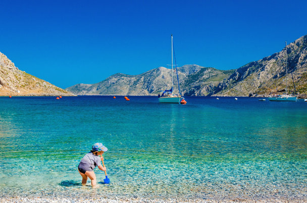 Niet-geïdentificeerde kind spelen op zee baai, Griekenland - Foto, afbeelding