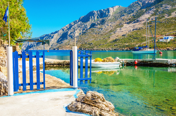 Niewielki port z łodzi i niebieskie bramy, Grecja - Zdjęcie, obraz