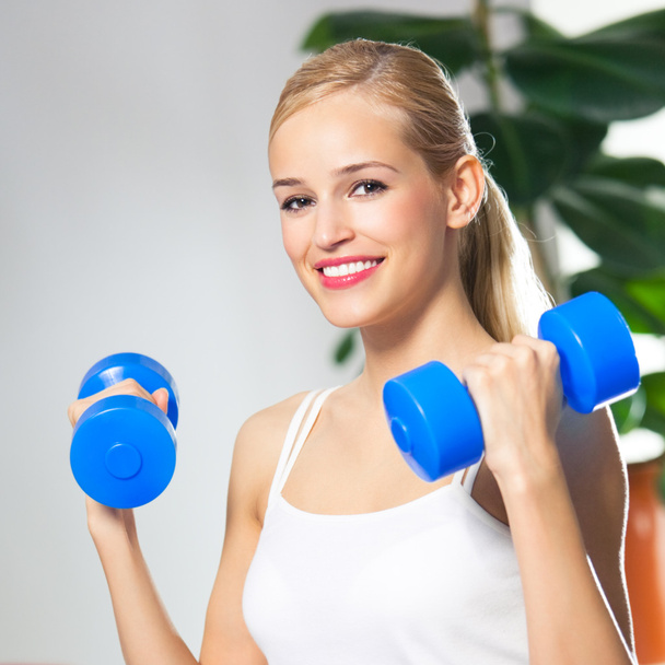Woman exercising with dumbbells, at home - Fotoğraf, Görsel