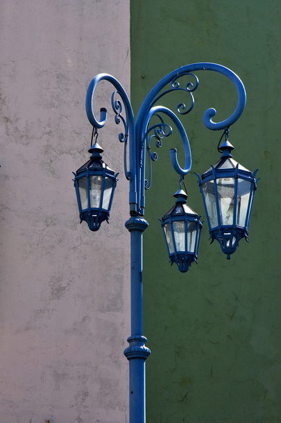 Lámpara de calle azul y una pared verde blanca
  - Foto, imagen