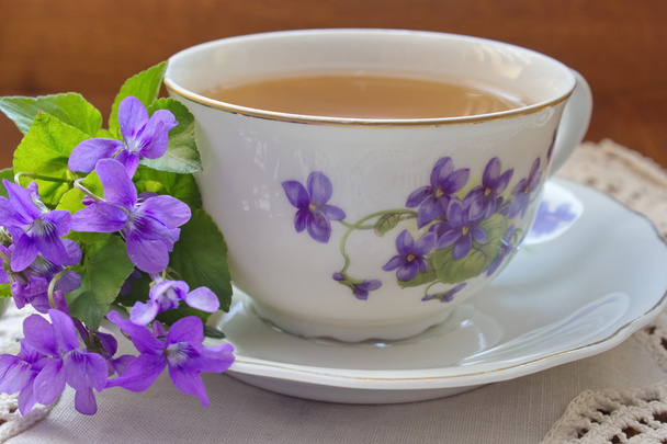 Taza de té vintage con motivo de violetas con flores violetas
 - Foto, Imagen