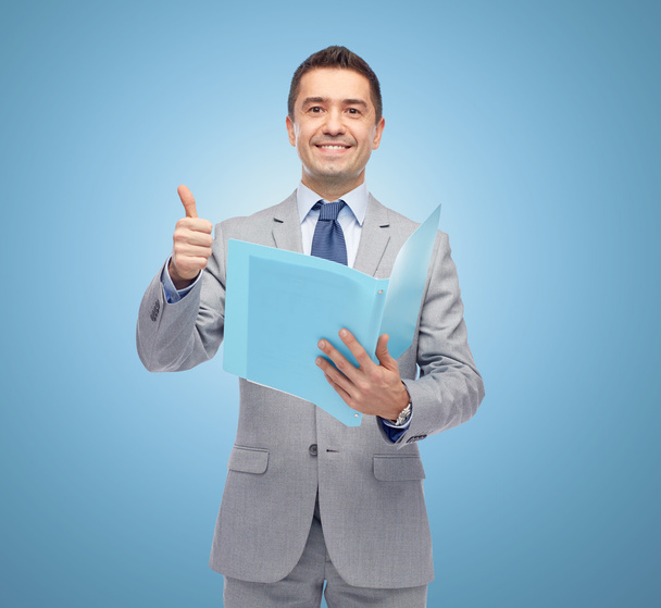 happy businessman with folder showing thumbs up - Фото, изображение