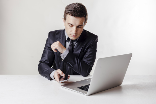 Close up image of multitasking business man using a laptop and mobile phone - Foto, Bild