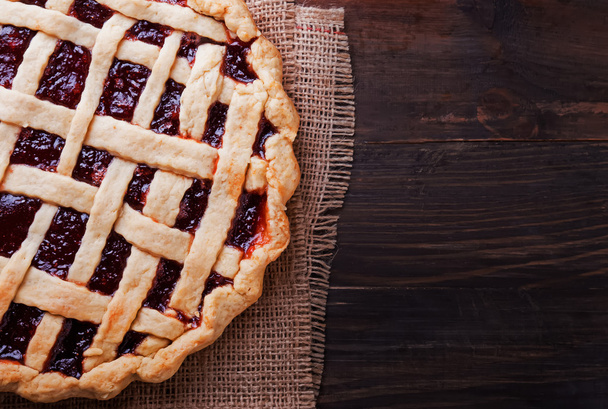 Homemade pie with jam on the wooden table. Dark toned photo. - Φωτογραφία, εικόνα