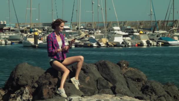 Žena modelu odpověď mobilní telefon proti yacht club - Záběry, video