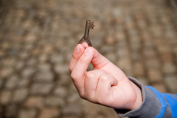 Main d'enfant tenant une vieille clé
 - Photo, image
