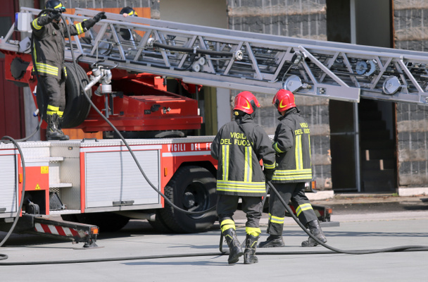 bombeiros durante uma emergência com fatos de protecção
 - Foto, Imagem