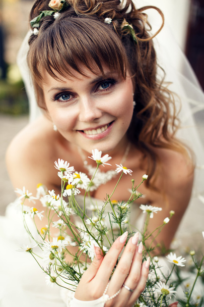 jonge gelukkige bruid met bloemen - Foto, afbeelding